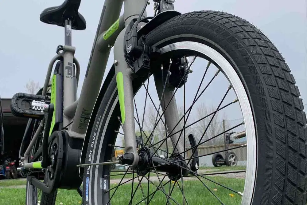 Vorderrad und Rahmen eines grauen i:SY E-Bikes mit grünen Akzenten