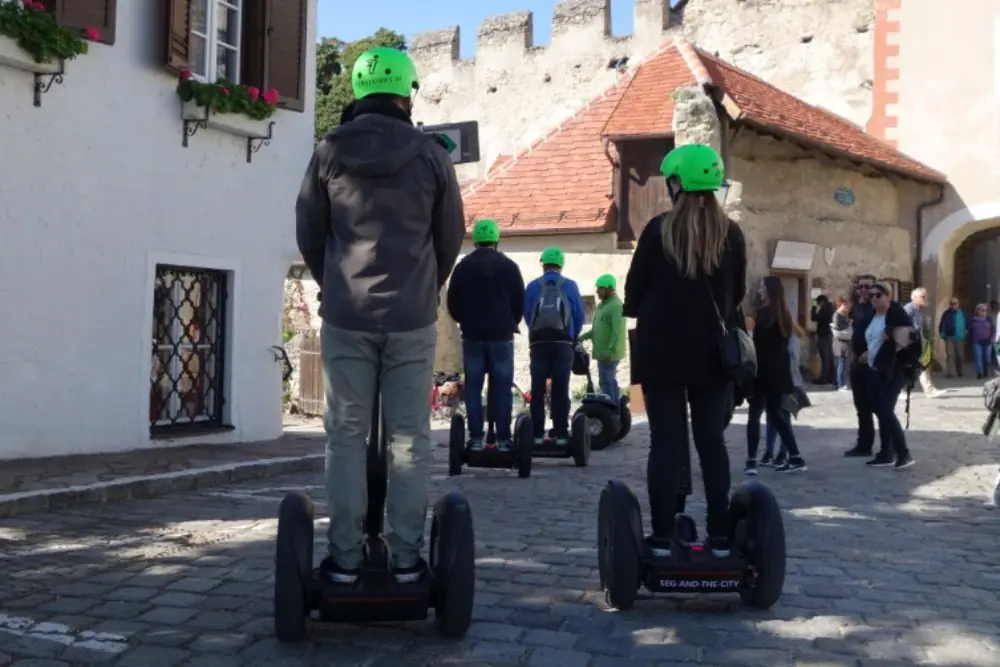 Segway-Gruppe mit grünen Helmen auf dem Kopfsteinpflaster einer Altstadtgasse